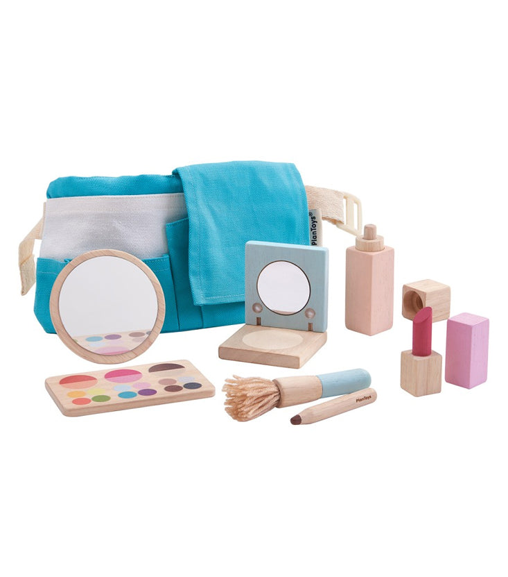 Pictured is a wooden makeup set that features a blue utility belt, pretend makeup palette, mirror, compact, perfume bottle, lipstick, eyeliner, and makeup brush. Pictured against a white background.