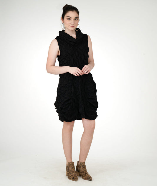 model in a black textured sleeveless tunic with an oversized cowl neck, princess seams and pockets set into the side seams