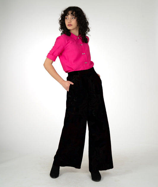 model is wearing a hot pink button down with black pants