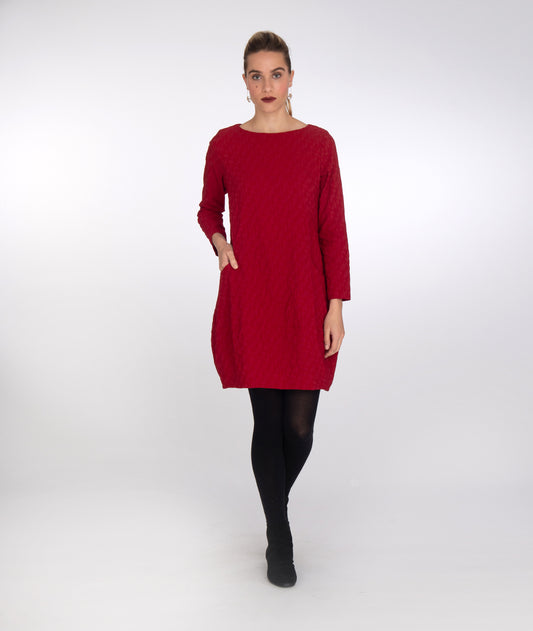 model in a red, long sleeve tunic with a wide band at the bottom hem