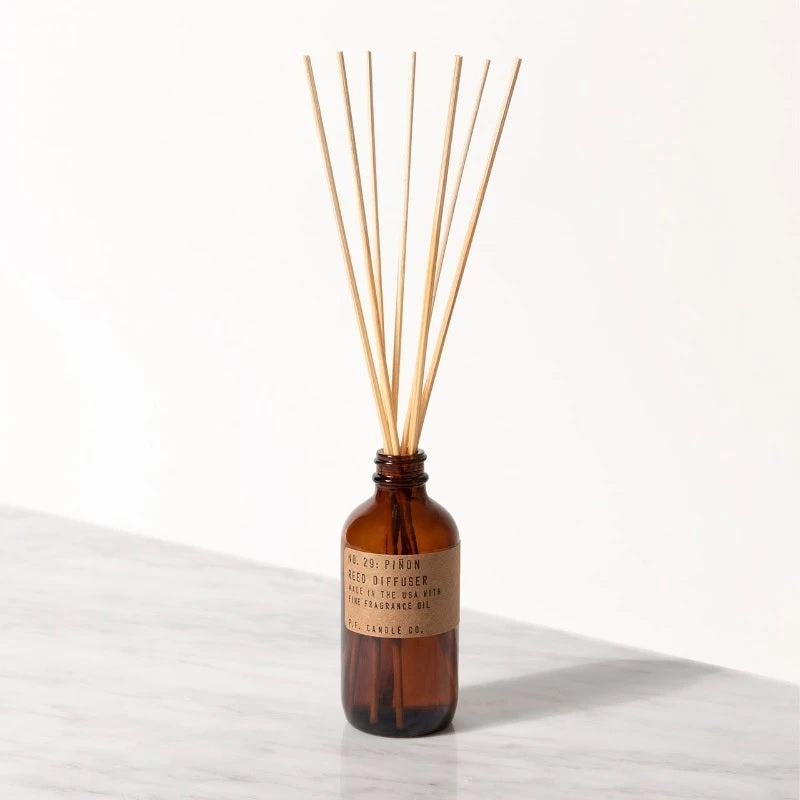 reed diffuser in a brown container with seven reed sticks coming from the top