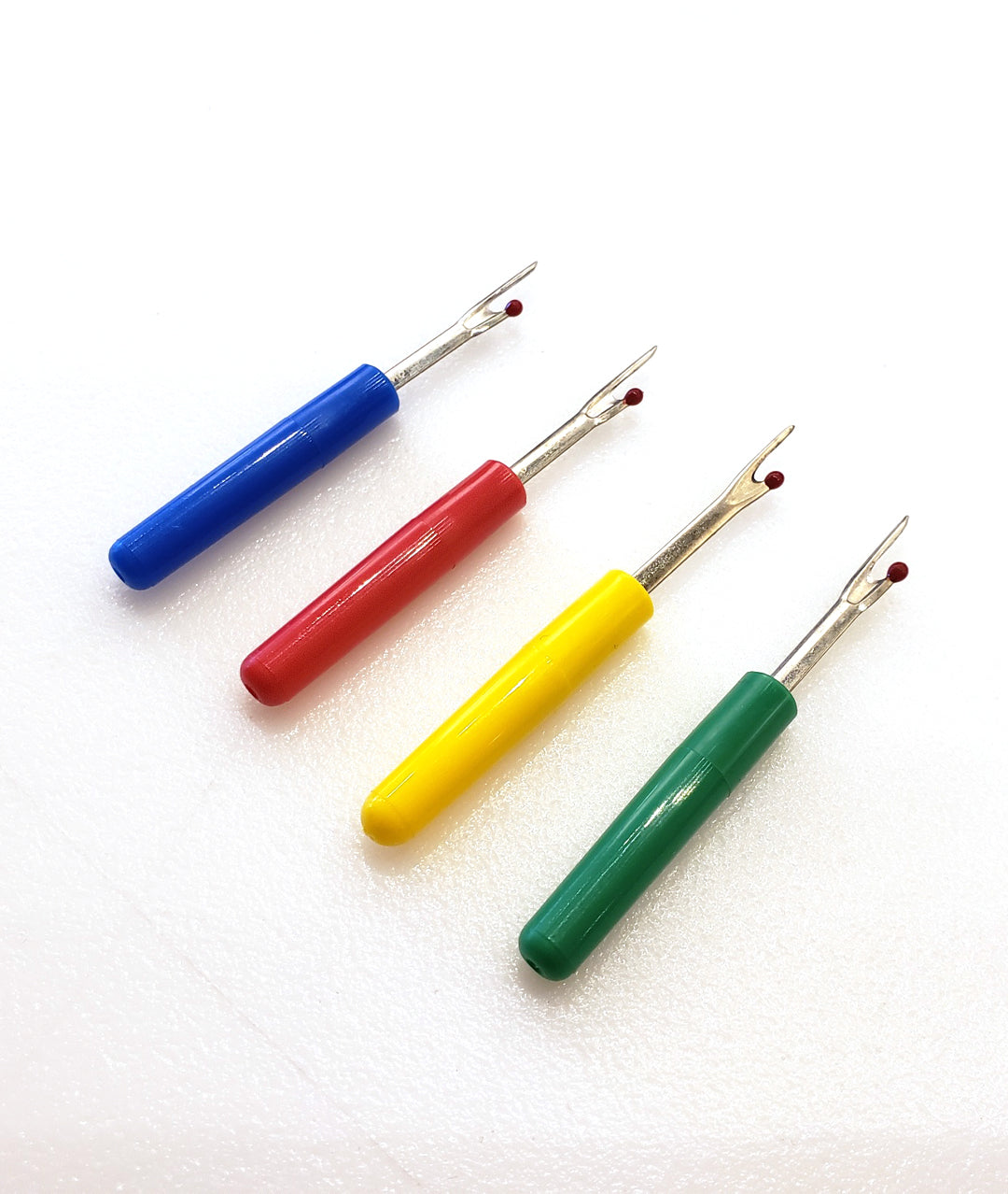 blue, red, yellow and green seam rippers on a white background